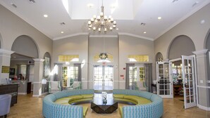 A spacious lobby with a central seating area, a chandelier, and a reception desk. - Location,Location,Orlando3bdr 2bthl,Resort near all parks, Conv.Ctr, Int. Dr (Orlando)