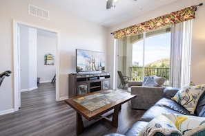 Relax in this serene living space with a comfortable sofa, coffee table, and large window offering a peaceful view.