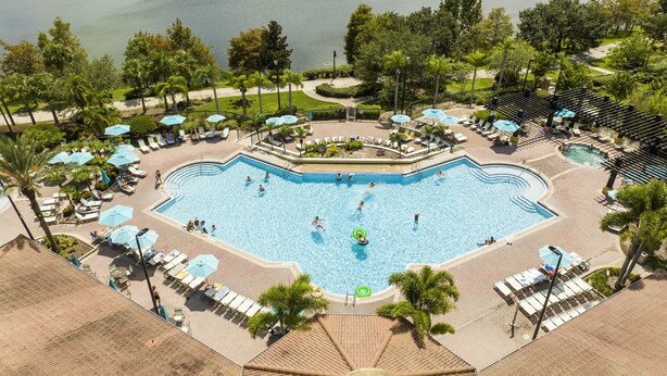 A large, multi-level swimming pool with various seating areas and palm trees. - Location,Location,Orlando3bdr 2bthl,Resort near all parks, Conv.Ctr, Int. Dr (Orlando)