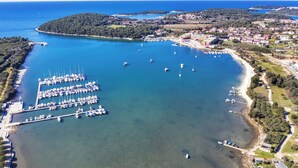 An aerial view of a marina with boats docked, surrounded by a coastal town with buildings and greenery. - Studio with air conditioning and WLAN (Pula)