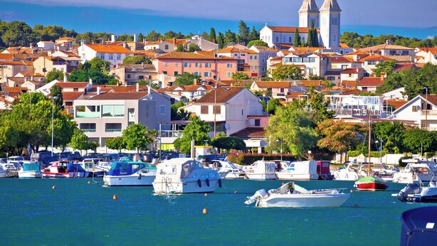 A coastal town with a prominent church and multiple boats docked in the harbor. - Studio with air conditioning and WLAN (Pula)