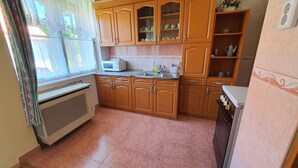 A compact kitchen with wooden cabinets, a microwave, and a sink.