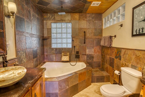 A bathroom with a freestanding bathtub, a toilet, and a sink.