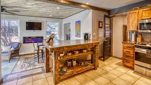 Una cocina moderna con una isla de madera, electrodomésticos de acero inoxidable y un amplio ventanal con vistas al exterior.