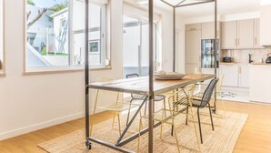 A modern kitchen with white cabinets, a stainless steel refrigerator, and a wooden countertop.