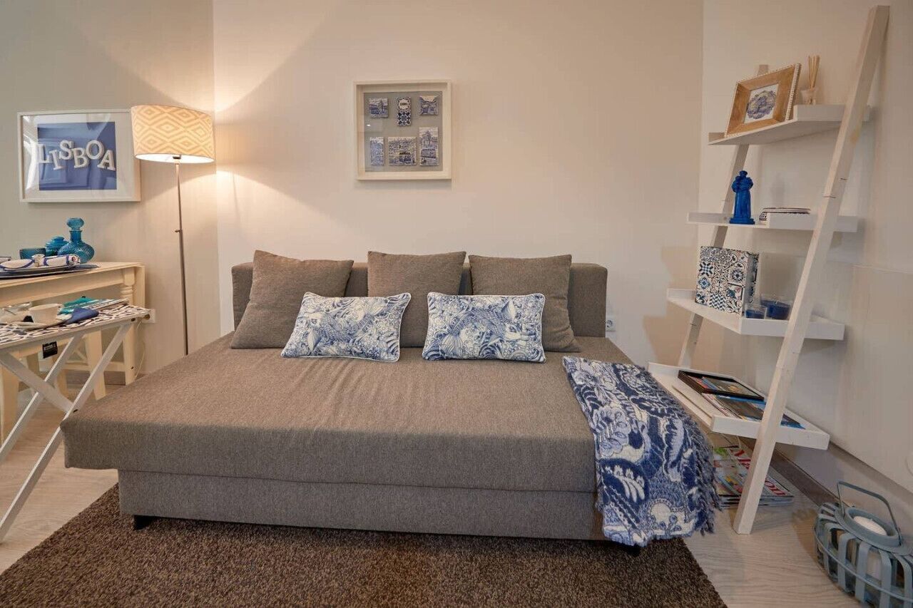 Ein Schlafzimmer mit einem Bett, einem Nachttisch, einer Lampe, einem gerahmten Bild und einem Regal mit Dekorationen.