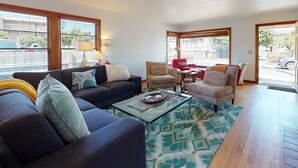 A living room with a sofa, armchairs, a coffee table, and a patterned rug.