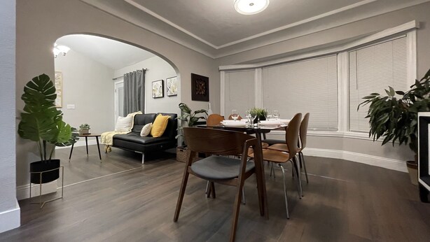 A modern living room with a dining area, featuring a sofa, dining table, and chairs. - Airy Modern 2BR/2BA - Parking + Laundry + Sleep 6 (San Jose)