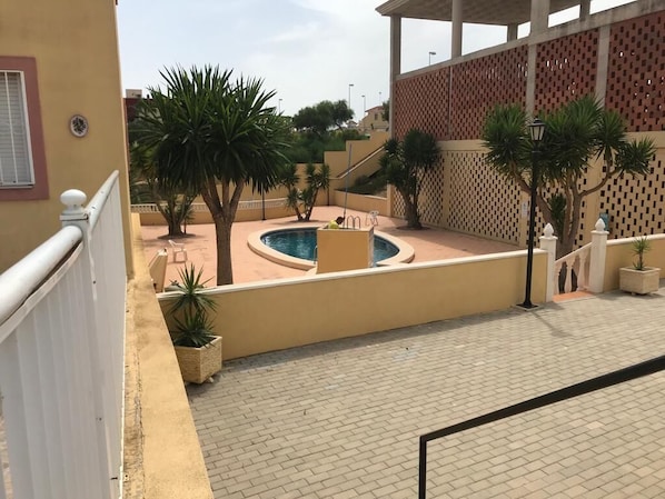 Relax by the pool surrounded by lush greenery and palm trees.