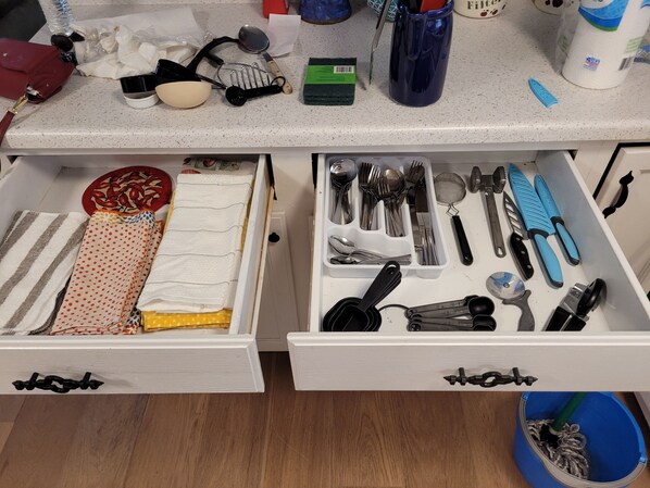 A kitchen counter with various kitchen utensils and a sponge.