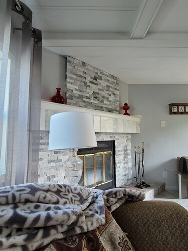 Spacious mobile home with large kitchen/living area and porch with barbeque.