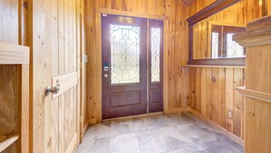 A wooden interior with a double door featuring decorative glass panels.