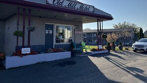 The exterior of the Old Mill Motel with a reception area, guest parking, and a sign indicating the motel's name. - Old Mill Motel (Blind River)