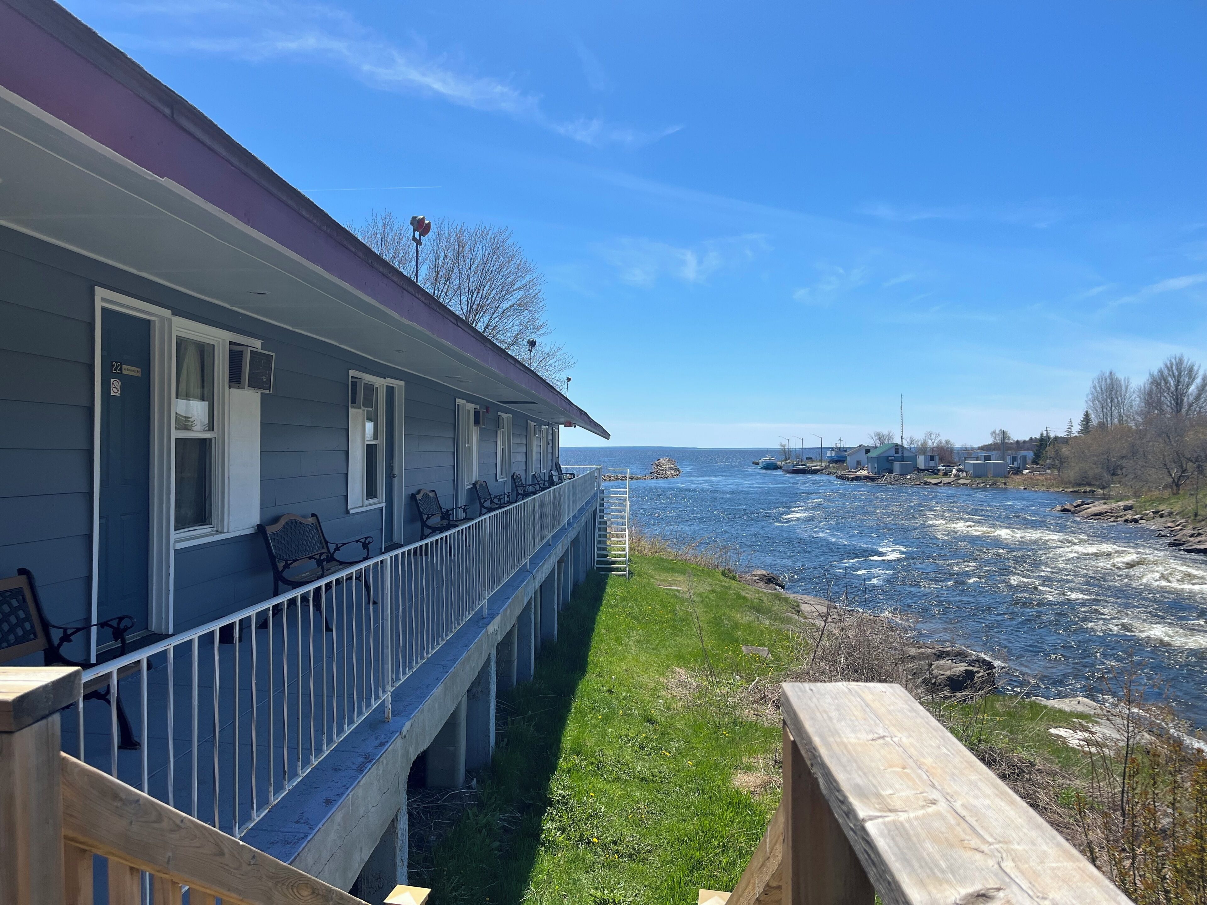 A waterfront property with a covered porch, outdoor seating, and a view of the river.