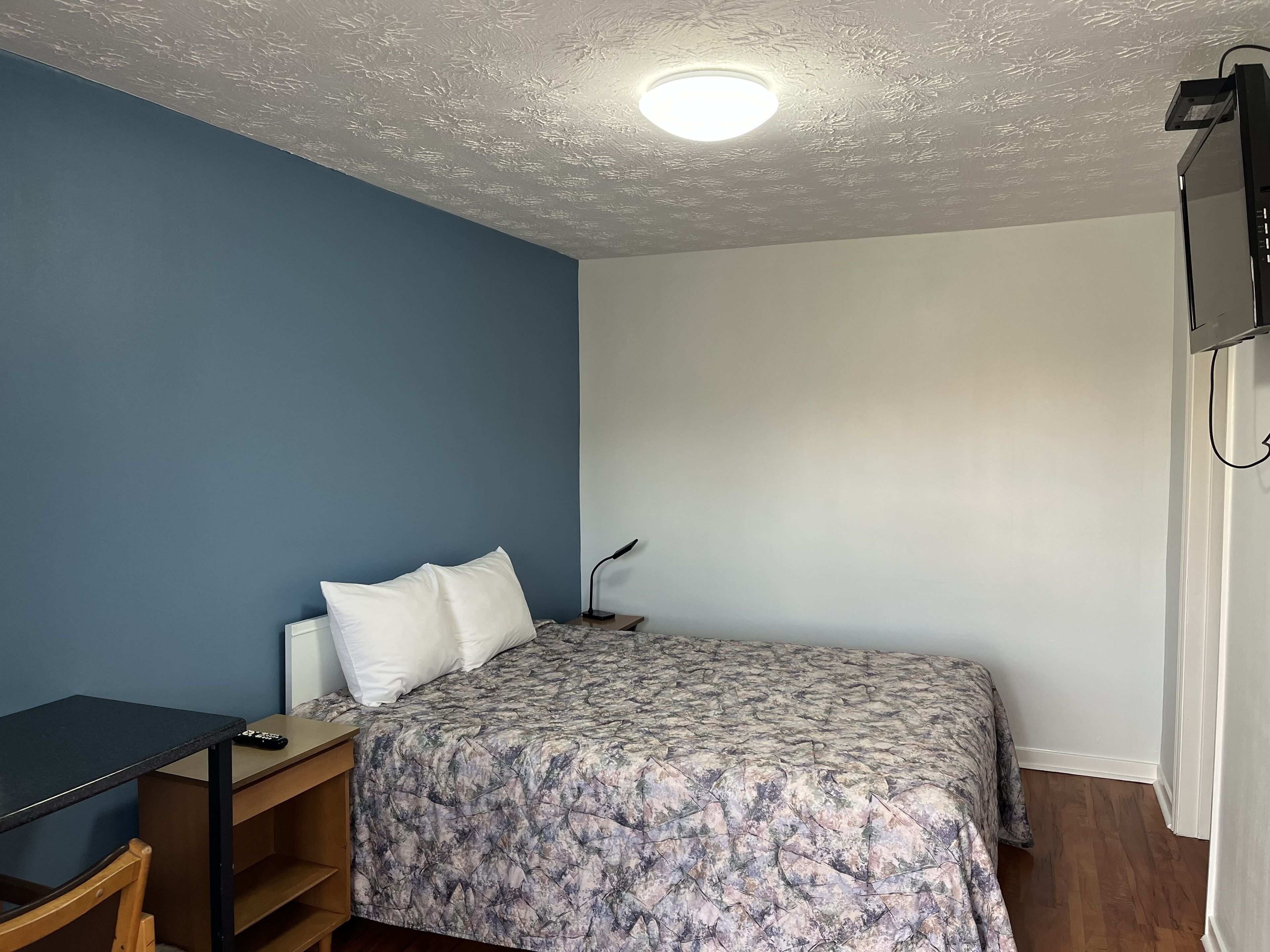 Un dormitorio con cama, escritorio y silla.