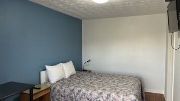 Un dormitorio con cama, escritorio y silla.
