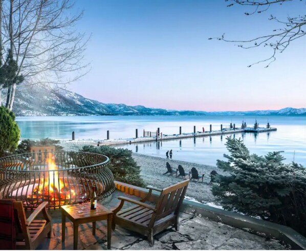 Relax by the lake with a fire pit and comfortable seating.