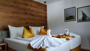 A neatly made bed with white and yellow bedding, a wooden headboard, and two framed pictures on the wall. - Vacation apartment Breitenberg approx. 50 sqm (Rottau)