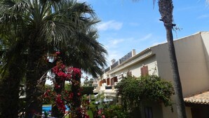 Un immeuble d’habitation doté d’un toit plat, d’un balcon et surplombant un ciel bleu dégagé.