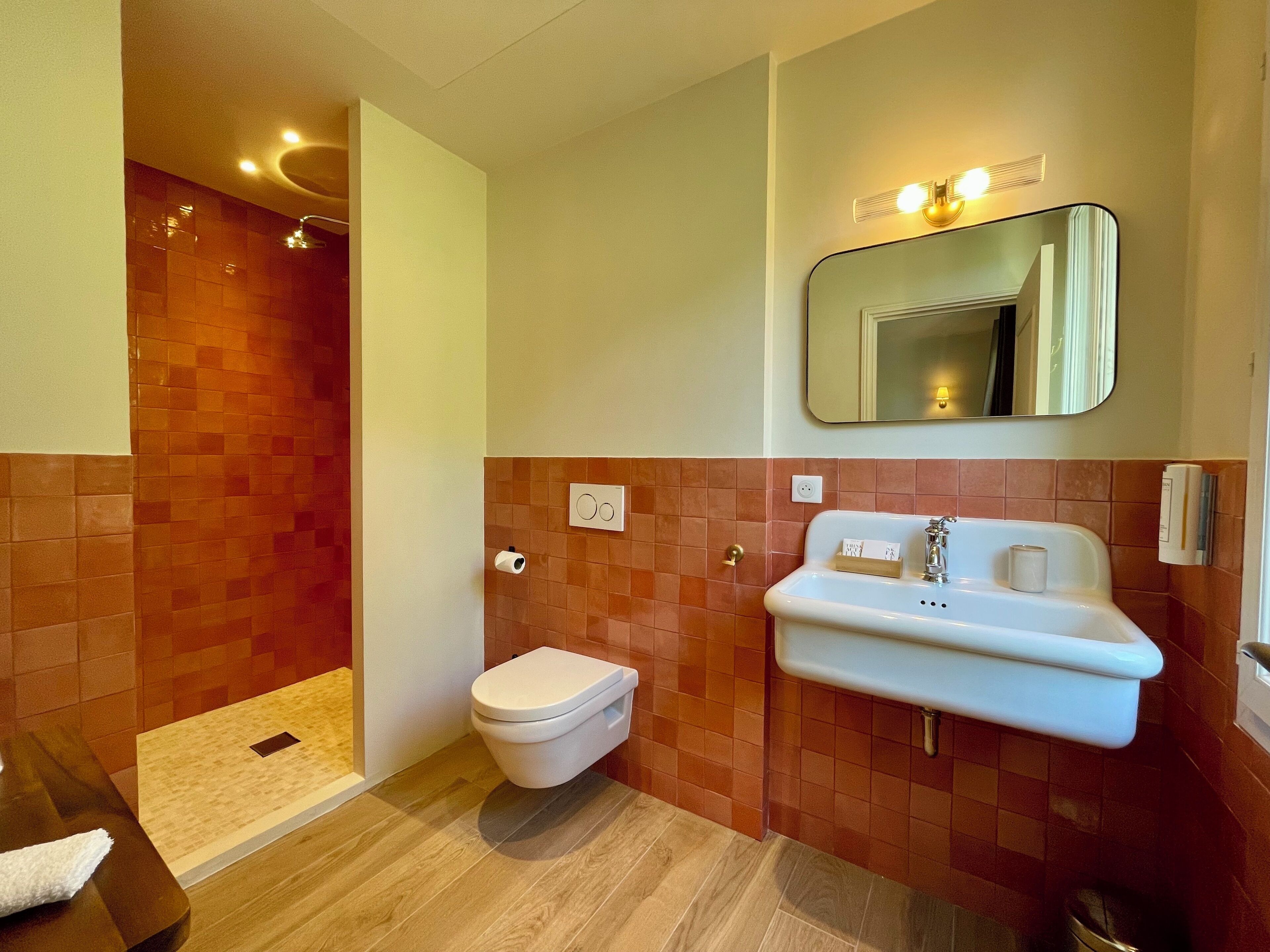 A modern bathroom with a shower, toilet, and sink.