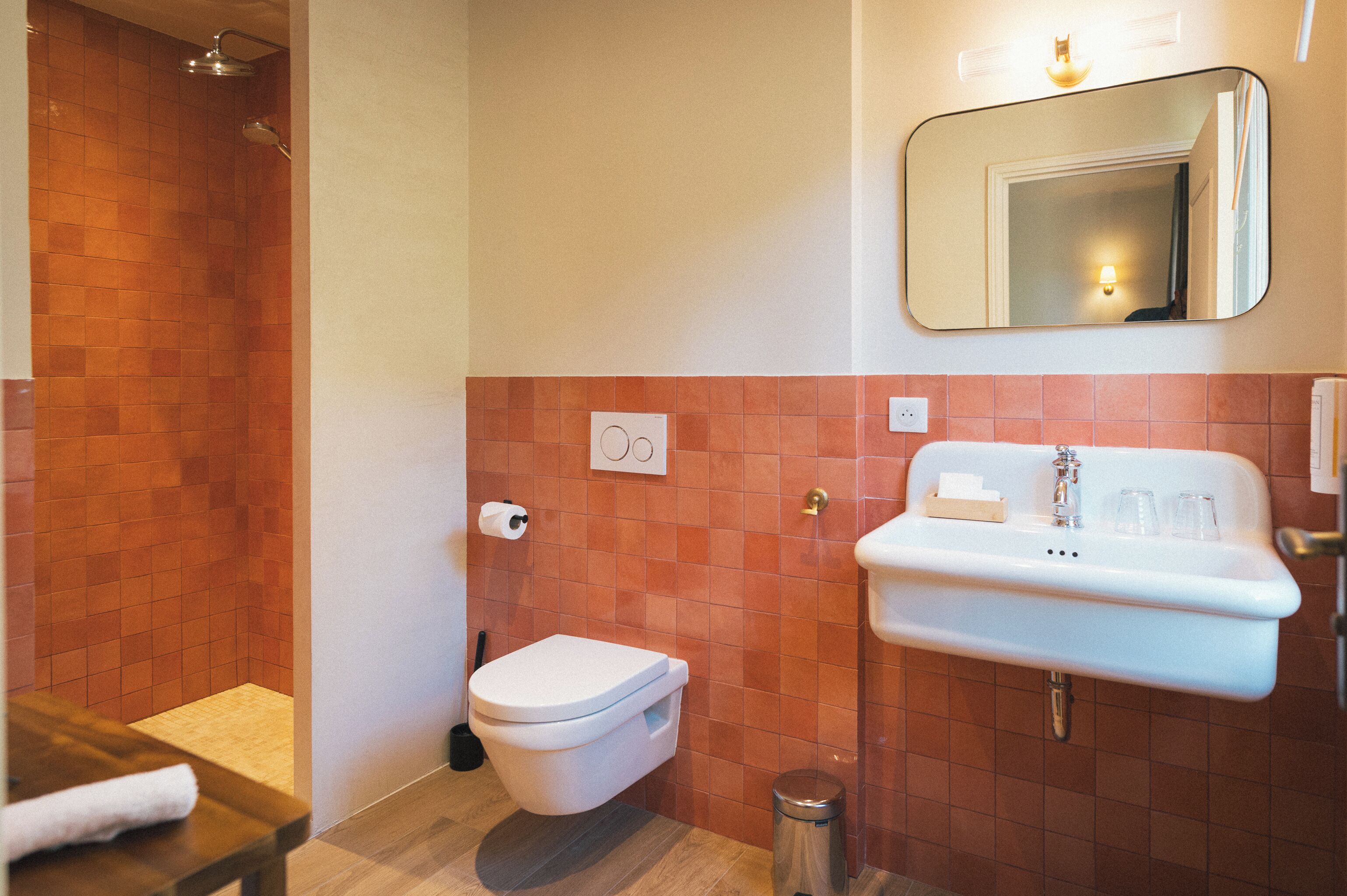 Une salle de bain équipée d’une douche, de toilettes, d’un lavabo et d’un miroir.