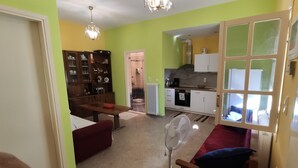 Un espace de vie compact comprenant un coin repas, une kitchenette et une salle de bain visible.