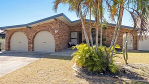 A brick house with two garage doors, a small porch, and a cactus in the yard. - Pet Friendly / Stroll to the beach (WOORIM)