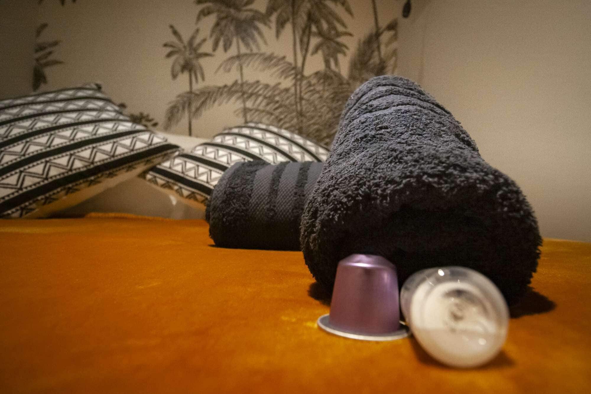 Un objeto negro y texturizado sobre una superficie de madera, con una taza morada a su lado.