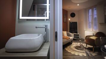 Un bagno moderno con una grande vasca da bagno e uno specchio sopra.