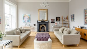 A living room with two sofas, a fireplace, and a chandelier. - Crescent House (Edinburgh)