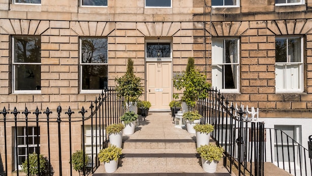A townhouse with a symmetrical facade, a central entrance with a door marked 'XII', and a staircase leading to the entrance. - Crescent House (Edinburgh)