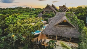 A resort with thatched-roof cottages surrounded by lush greenery. - Sunshine Bay Zanzibar - Adult Only (Matemwe)