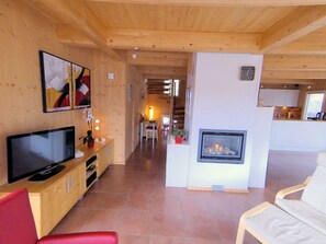 Una sala de estar moderna con chimenea, muebles de madera y televisor.