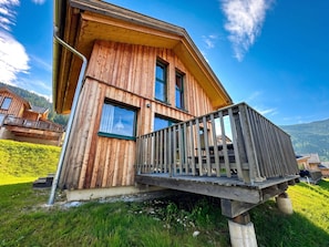 A wooden cabin with a balcony, surrounded by greenery and a clear sky. - Superior Chalet # 61 with IR-Sauna (Hohentauern)