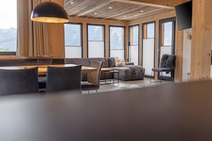 Un interior moderno con comedor, asientos y ventanas amplias.