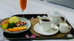 A hotel room with a bed, pillows, a lamp, a tray with breakfast, and a picture of Big Ben on the wall. - Bamboo Boutique (Lilongwe)