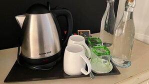 A kitchen area with a Grelide electric kettle, two white mugs, two green glass tumblers, and two clear glass bottles. - Bamboo Boutique (Lilongwe)