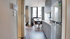Et moderne køkken med spiseplads, et køleskab og et vindue med gardiner.