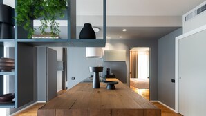 Uma cozinha moderna com mesa de madeira, banquetas e uma planta pendurada.