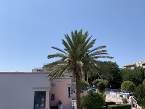 A building with a blue door, a palm tree, and a clear blue sky. - Rodos Town Luxury Apartment (Rhodes)