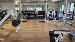 A gym with various exercise equipment, including weight machines and free weights.
