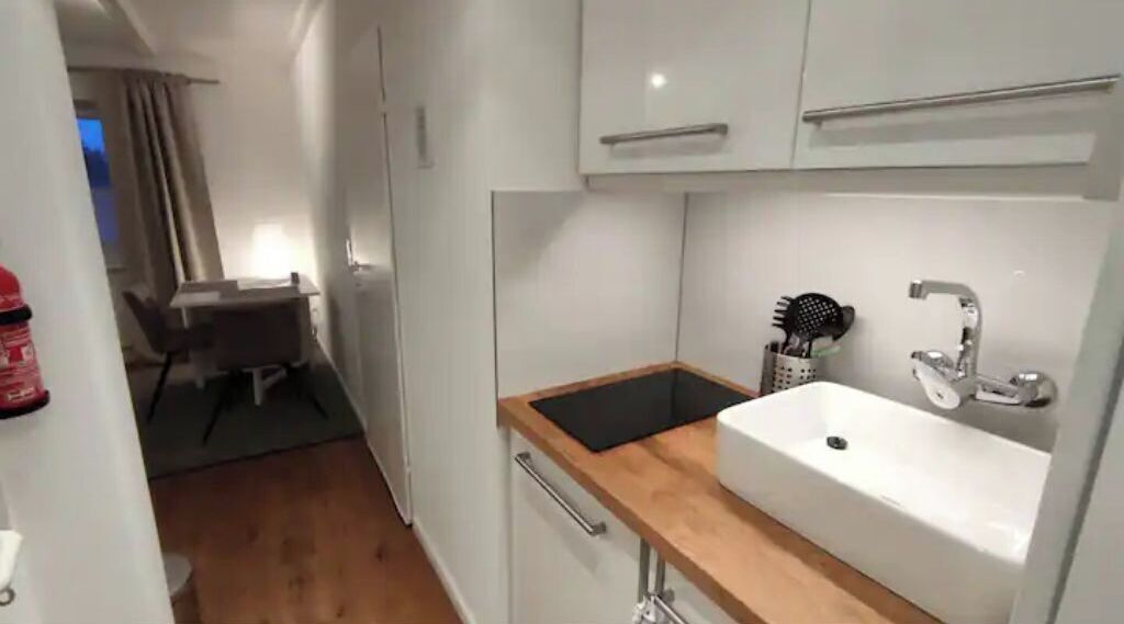 A compact kitchen with a sink, countertop, and cabinets.