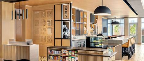 Un bar moderno con mostrador de madera, taburetes y una variedad de aperitivos y bebidas.