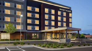 Un hotel moderno con un llamativo letrero de 'Hyatt Place', varios pisos y una zona de acceso cubierta.