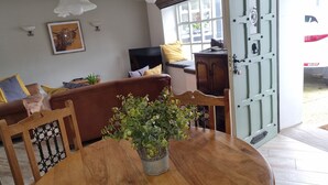 A dining area with a wooden table, chairs, and a potted plant. - Bashall Barn, Eaves Hall, Outbarn all Close by (Clitheroe)