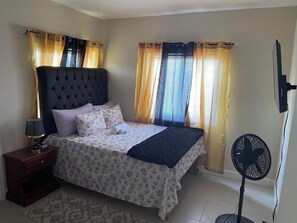 Restful retreat with a large bed, tufted headboard, and bedside table.