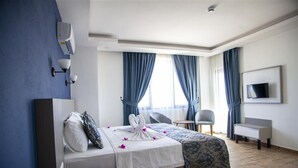 Ett hotellrum med en säng, ett skrivbord, en stol och en tv på väggen.