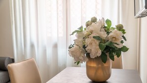 Ein Tisch mit einer Vase weißer Blumen.