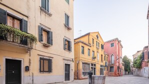 Eine enge Straße mit historischen Gebäuden, Pflasterweg und einem Mülleimer.