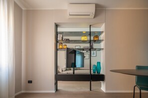 A modern living room with a glass partition, a dining table, and a sofa. - Accademia Design Apartment with Balcony R&R (Dorsoduro)